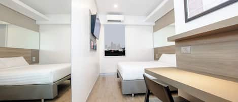 Una habitación de hotel moderna con dos camas, un escritorio y una silla.