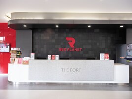 A Red Planet branded reception desk with a modern design, a digital screen, and informational brochures.