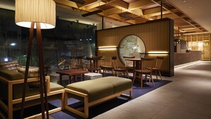 Un interior moderno con muebles de madera, una lámpara grande y un mapa en la pared.