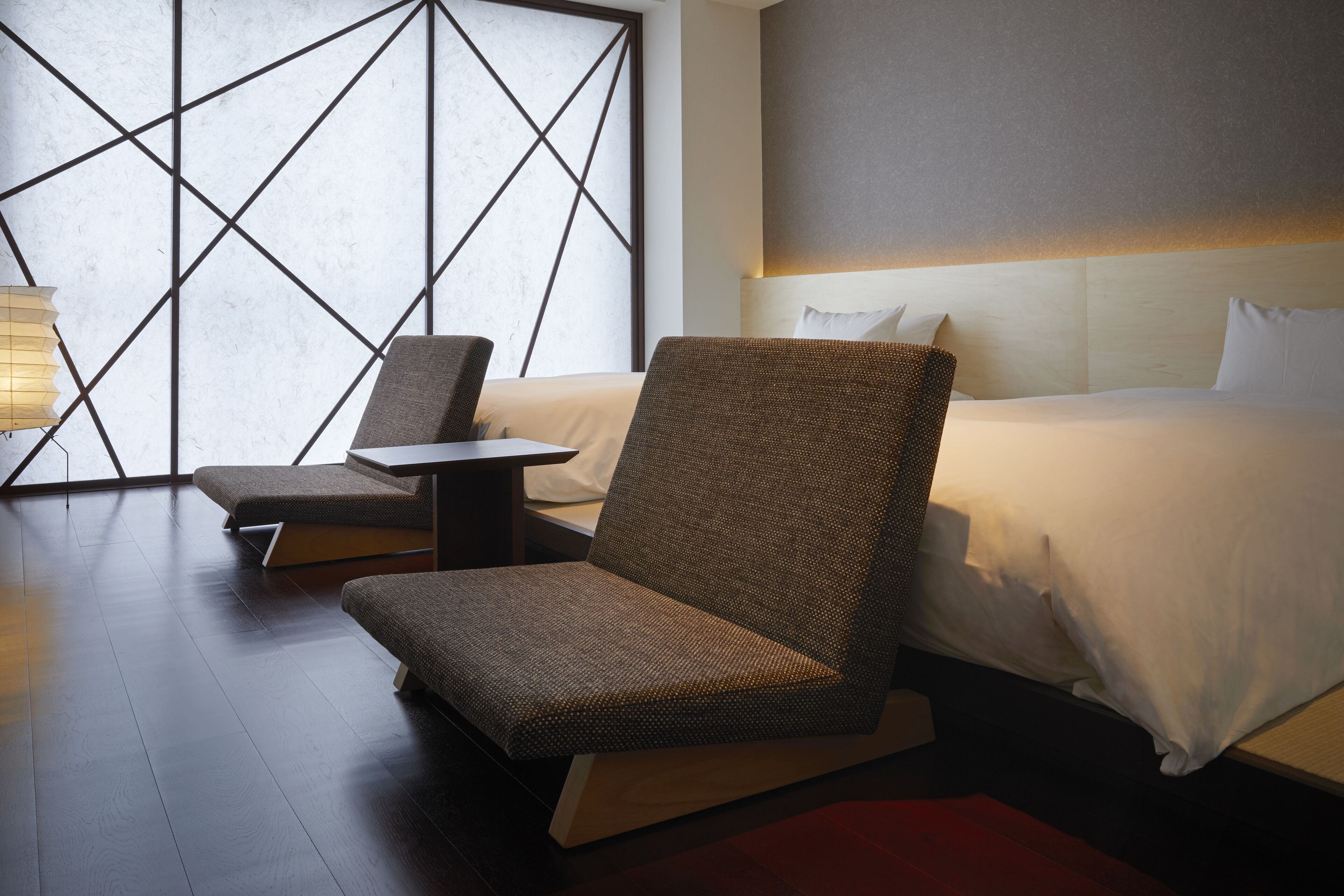 Une chambre d’hôtel avec un grand lit, un canapé, une petite table et une lampe.