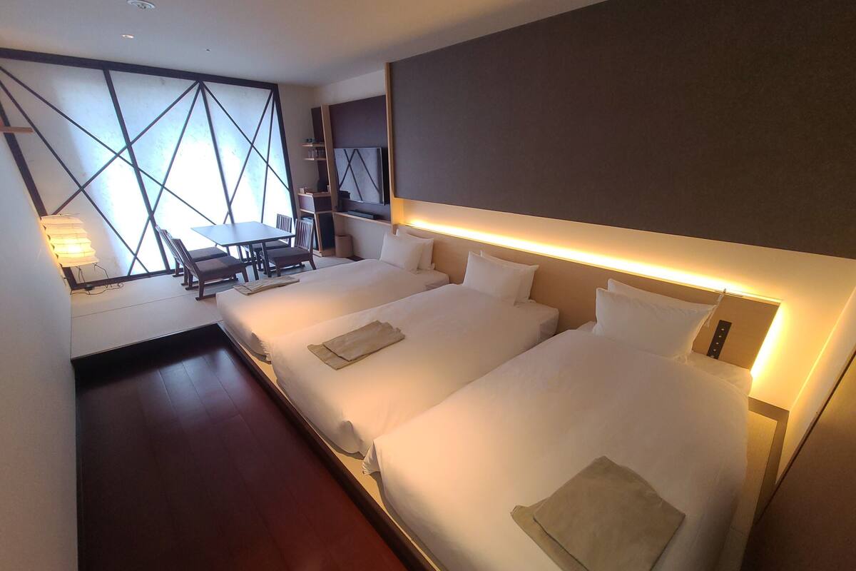Ein Hotelzimmer mit zwei Betten, einem Schreibtisch und einem Stuhl.