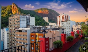 A cityscape with multi-story buildings, a prominent rock formation, and a mountain in the background. - 7 BRD  "The Coral Penthouse" w/360° | Beach | AC All Rm (Rio de Janeiro)