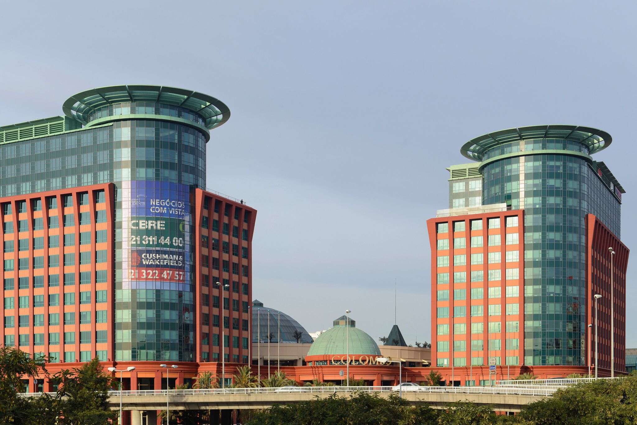 A modern building with two cylindrical glass towers and a dome structure.