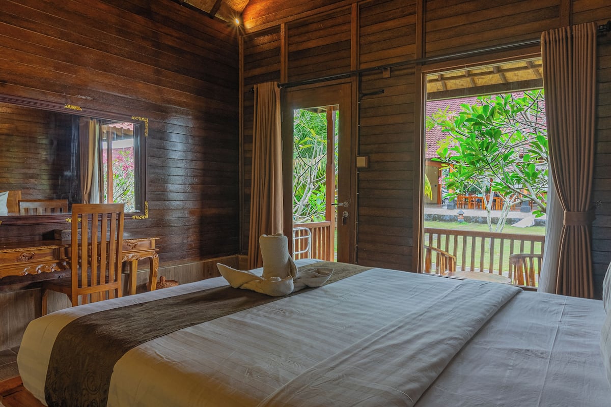 A wooden room with a bed, a desk, and a chair.