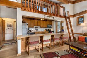 A spacious kitchen with wooden cabinets, a central island, and a lofted seating area. - 2 Bedrooms + Loft, Balcony w/ Great Views - Hot Tub - 30, Night Rentals + EZCancel (Steamboat Springs)