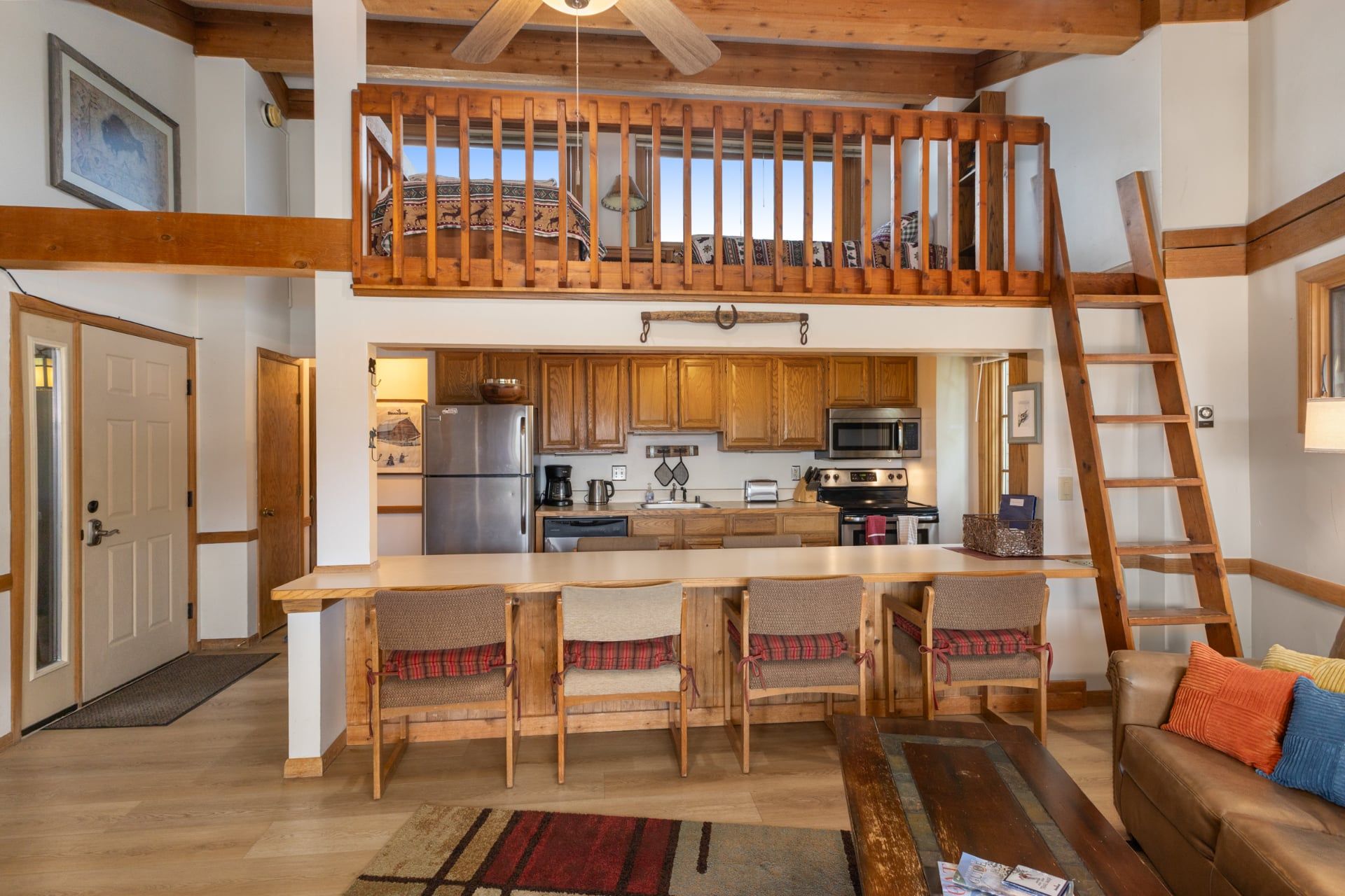 A spacious kitchen with wooden cabinets, a stainless steel refrigerator, and a microwave.