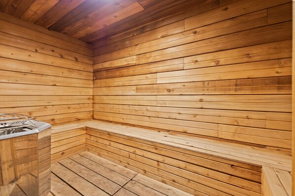 A sauna room with wooden walls and benches.