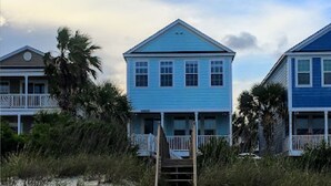 A beachfront property with two blue houses, a wooden fence, and a sandy beach. - 5 Bedroom & 5 Bath Beachfront House w/ Private Pool, Hot Tub & Beach Boardwalk! (Surfside Beach)