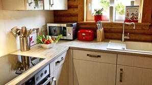 Eine kleine Küche mit einer Mikrowelle, einem roten Toaster und einem Spülbecken.
