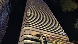 Un moderno edificio de gran altura con múltiples balcones y una fachada distintiva.