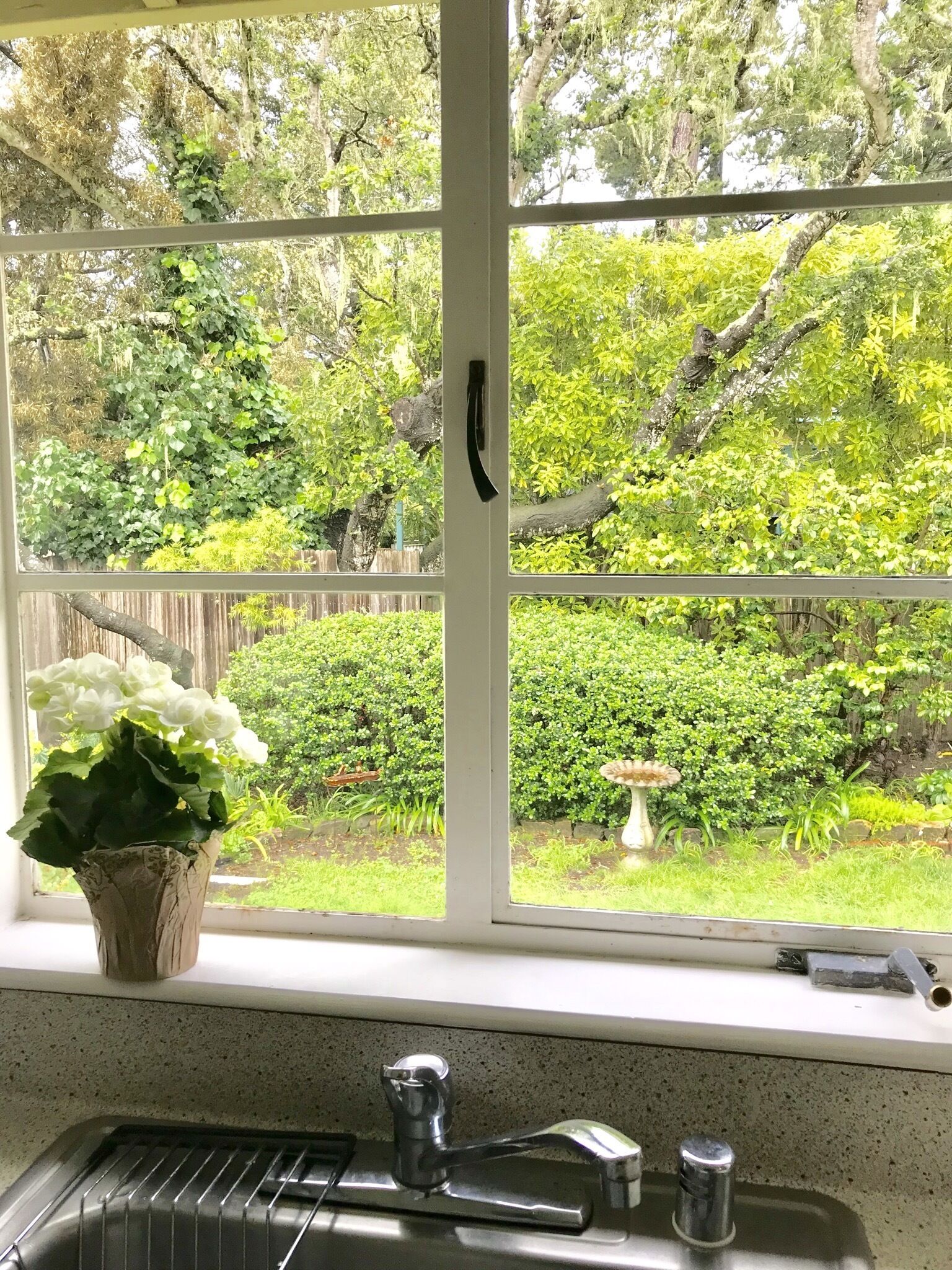 A kitchen with a window overlooking a garden.