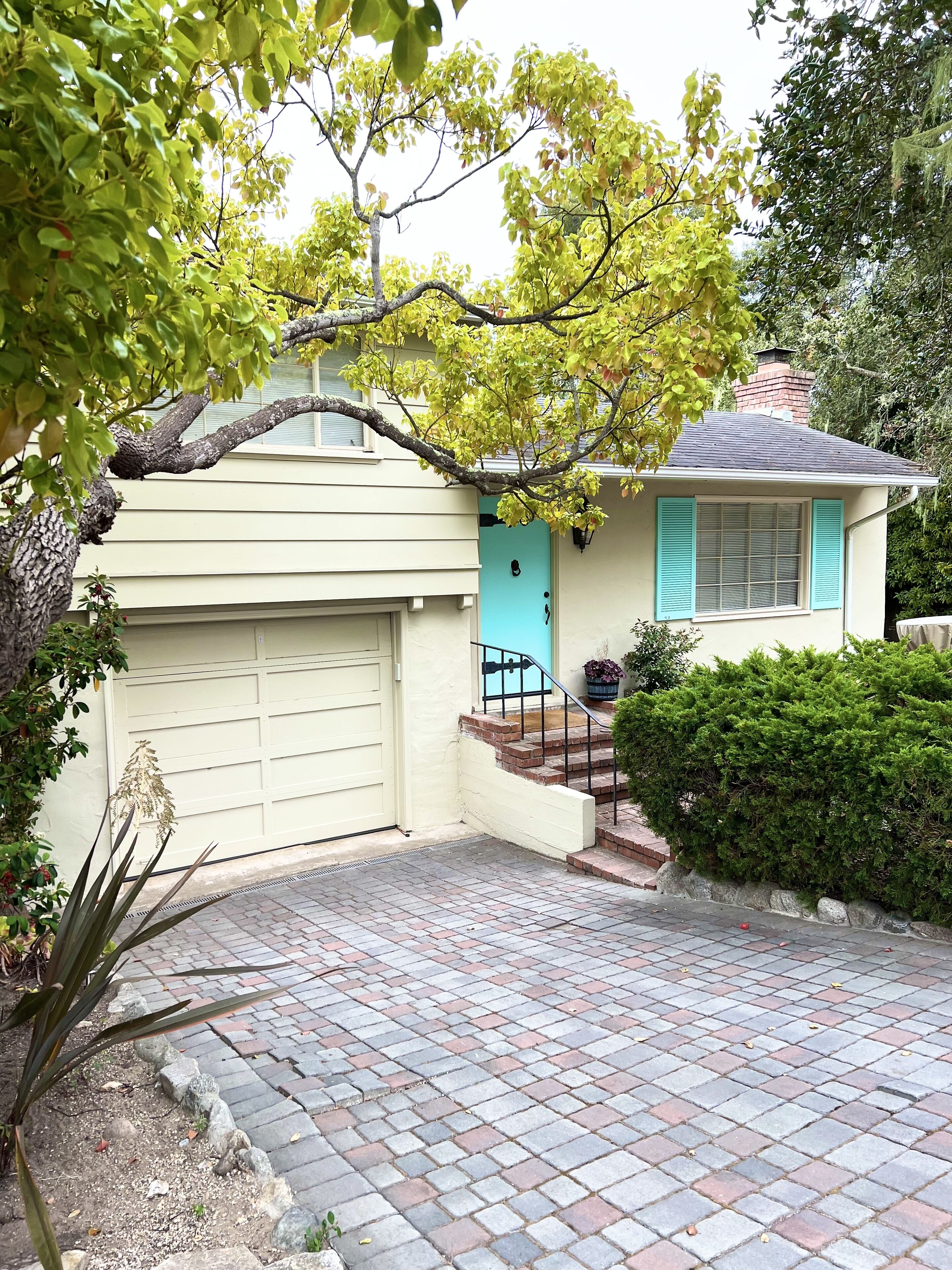 A house with a garage, a front porch, and a small garden area.