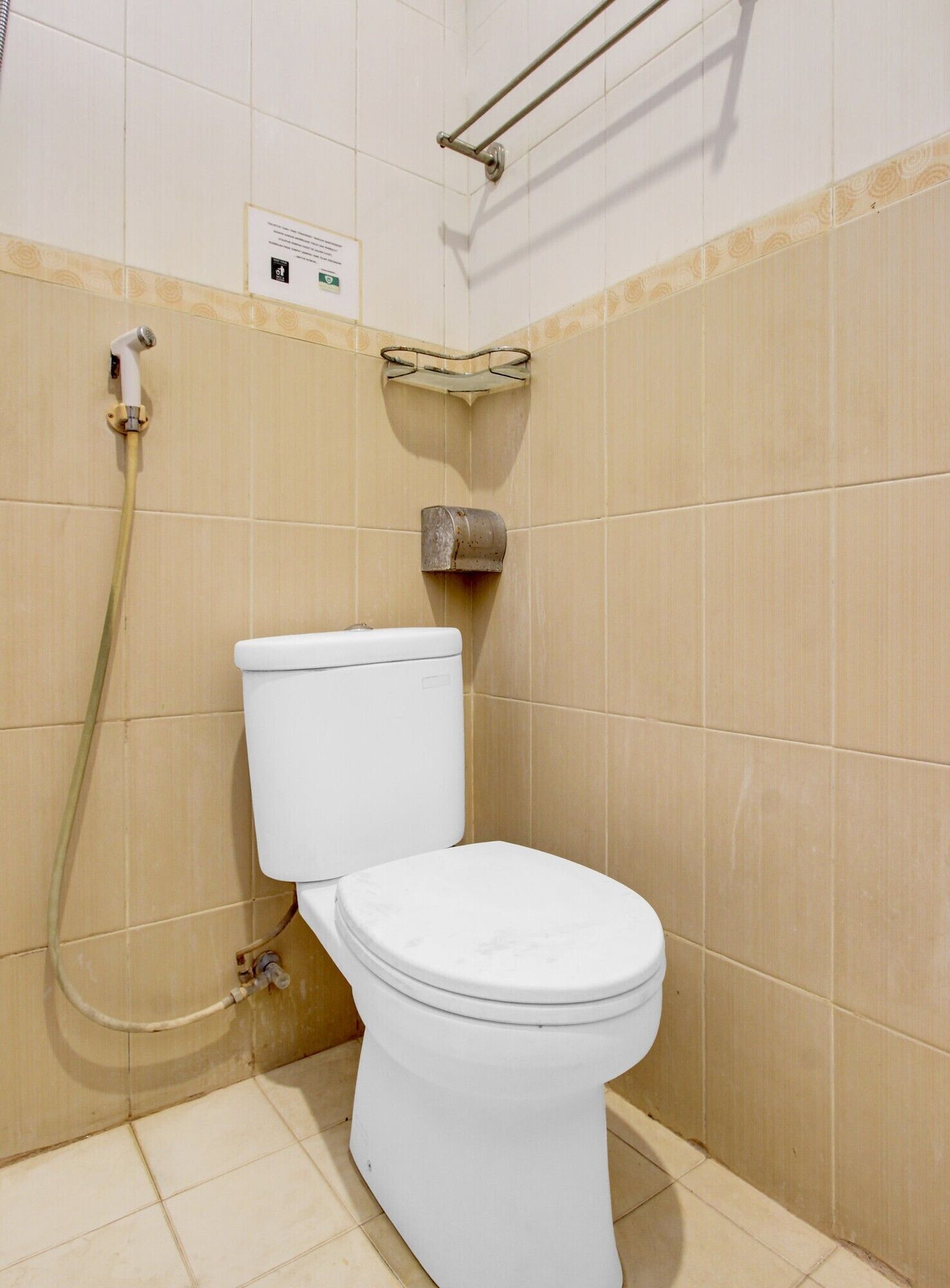 Une salle de bain équipée de toilettes, d’une douche et d’un sèche-mains.
