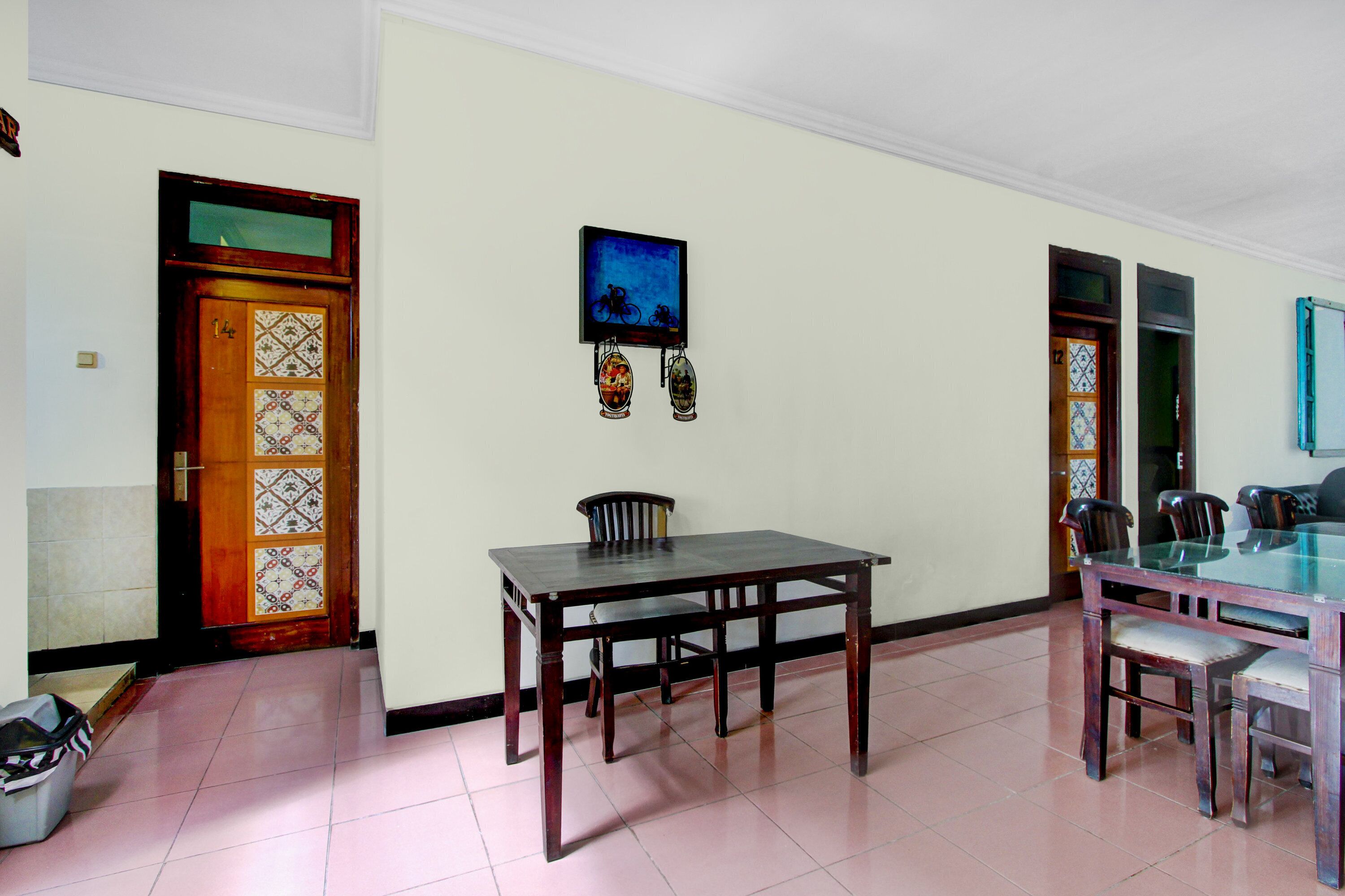 A dining area with a glass-top table, chairs, and a television mounted on the wall.