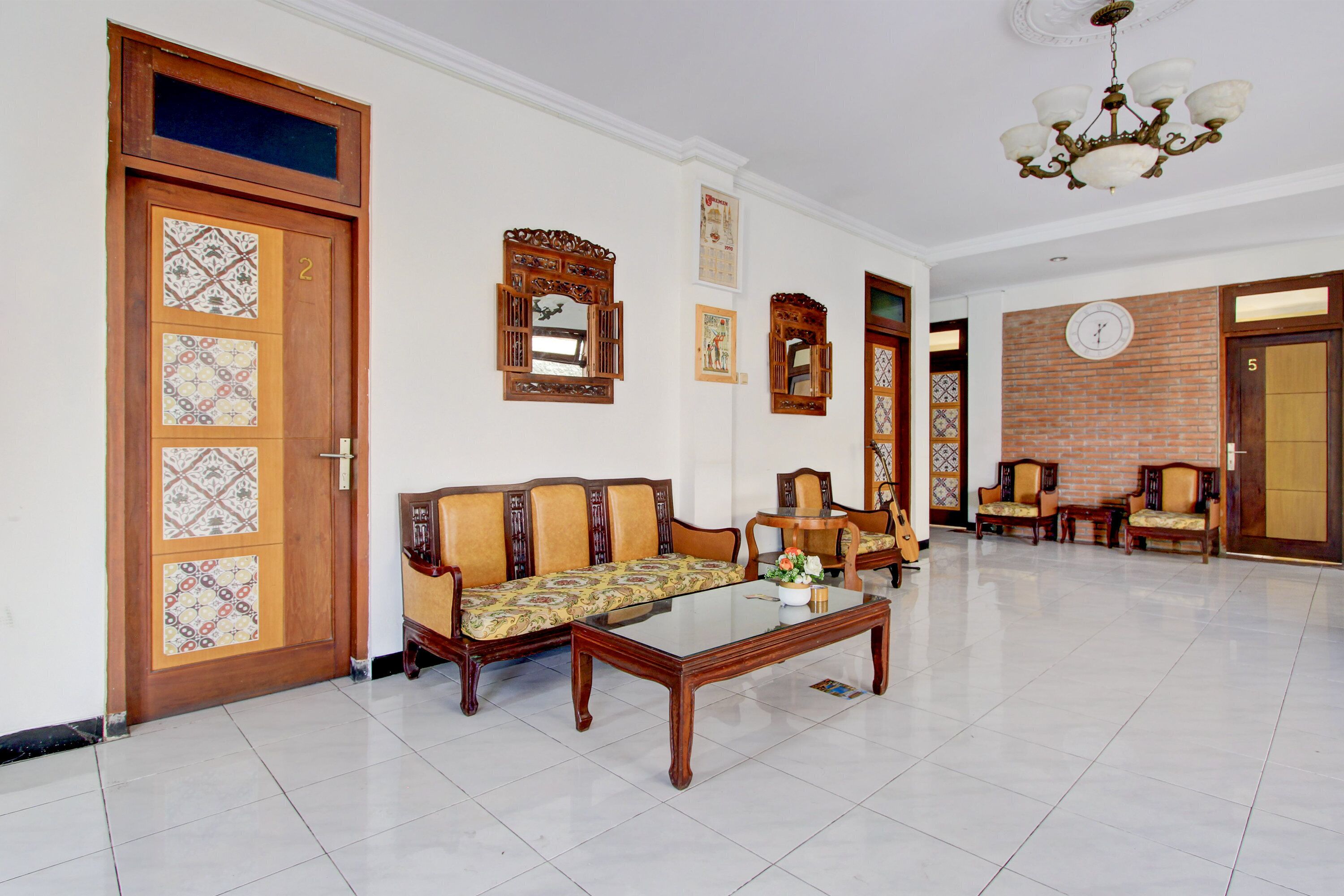 A spacious lobby with a sofa set, a coffee table, and a clock on the wall.