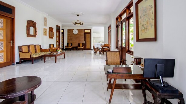 A spacious hotel lobby with a reception desk, seating area, and a wall-mounted map. - OYO 512 Ndalem Mantrijeron Hotel (Yogyakarta)