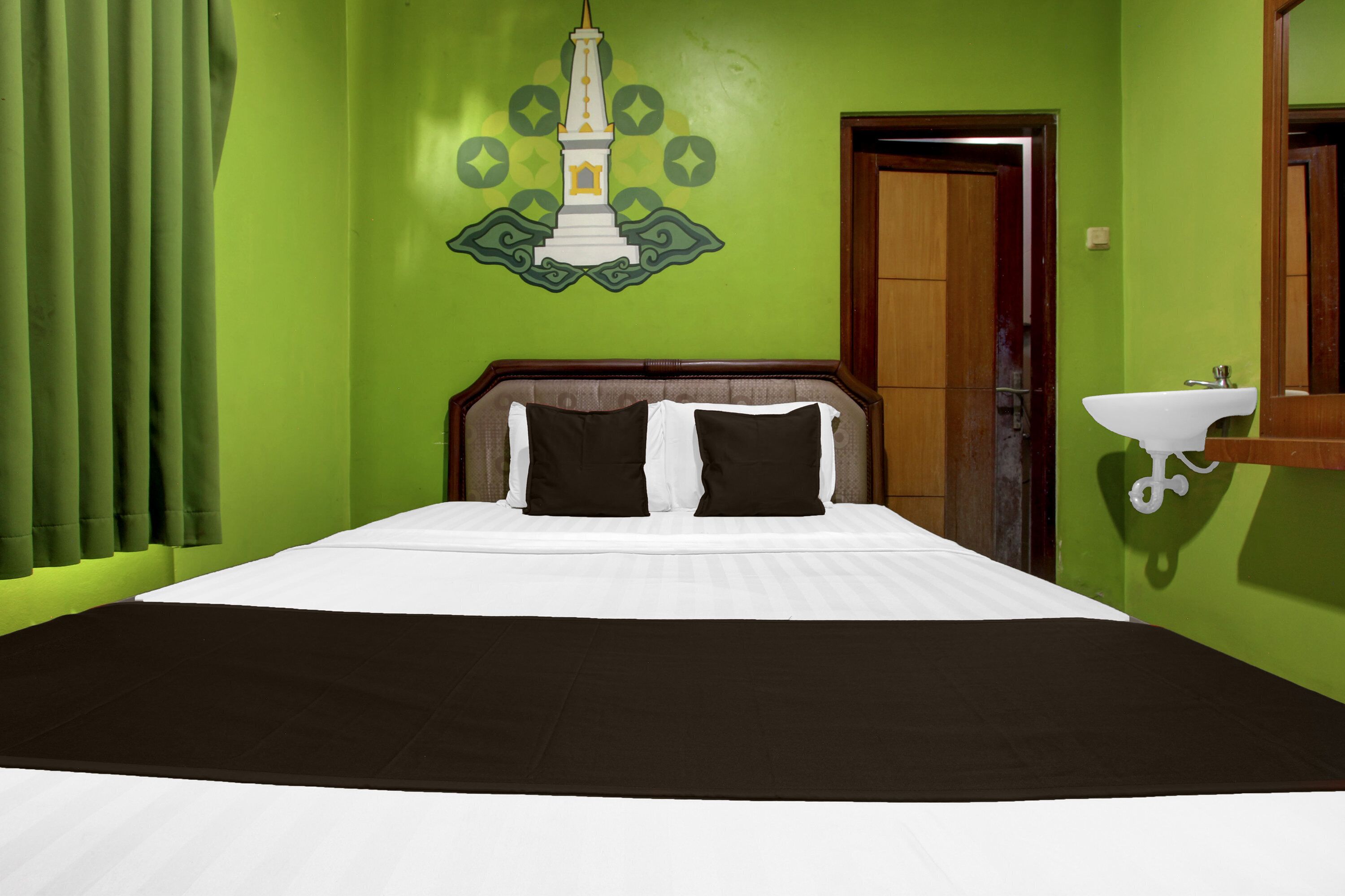 A room with a bed, a wall-mounted sink, and a door.