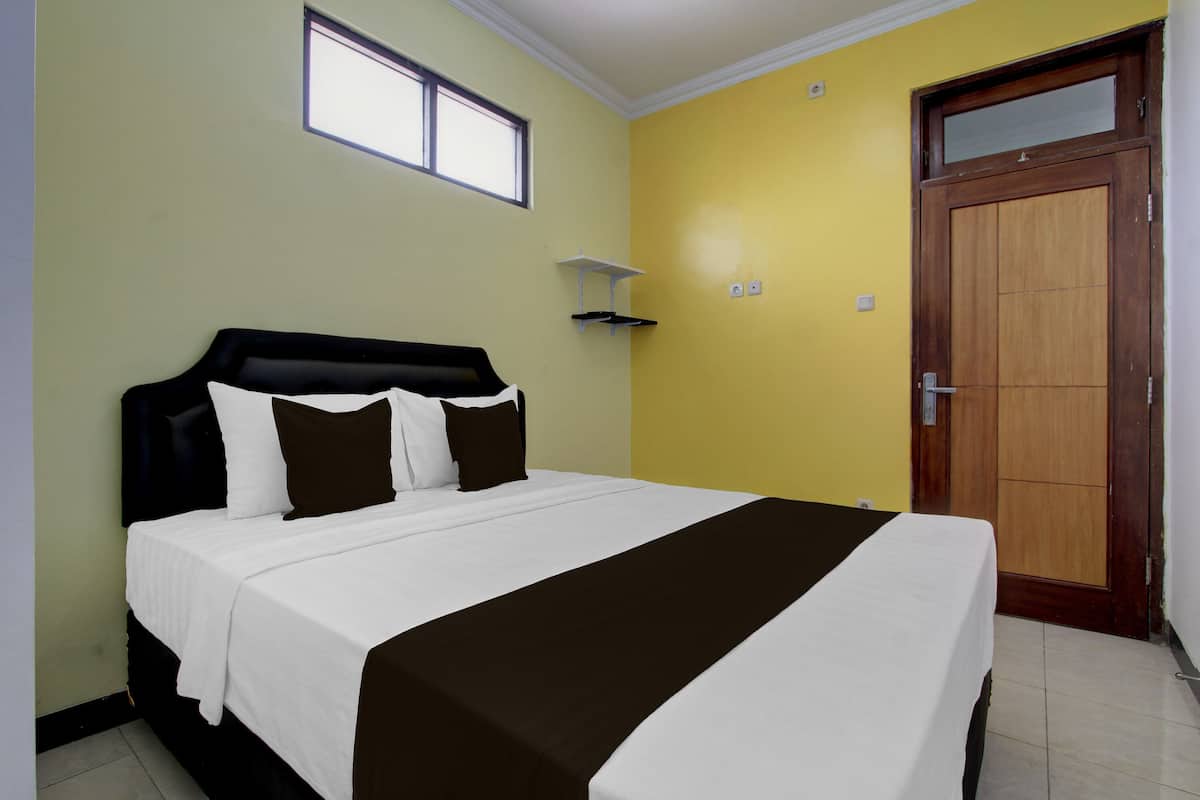 Quarto com cama, janela, porta e prateleira fixada na parede.