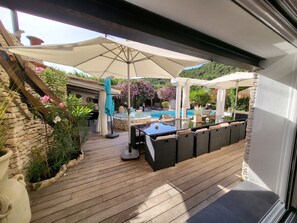 Patio esterno con piscina, decking in legno e mobili da giardino.