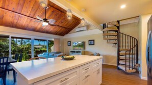 A modern kitchen with a wooden ceiling, a white island, and a spiral staircase. - Remodeled!! Koa Resort #5J 2-Bd 2-Ba, A/C, South Maui, Walk To 3 Beaches! (Kihei)