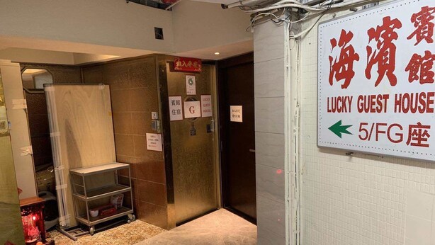 A hotel entrance with a sign for 'Lucky Guest House' and an arrow pointing to the 5th floor. - Lucky Guest House (Kowloon)