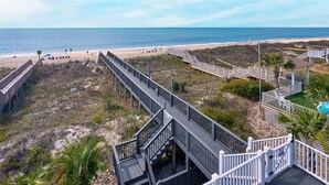A beach with wooden walkways and a pool area.