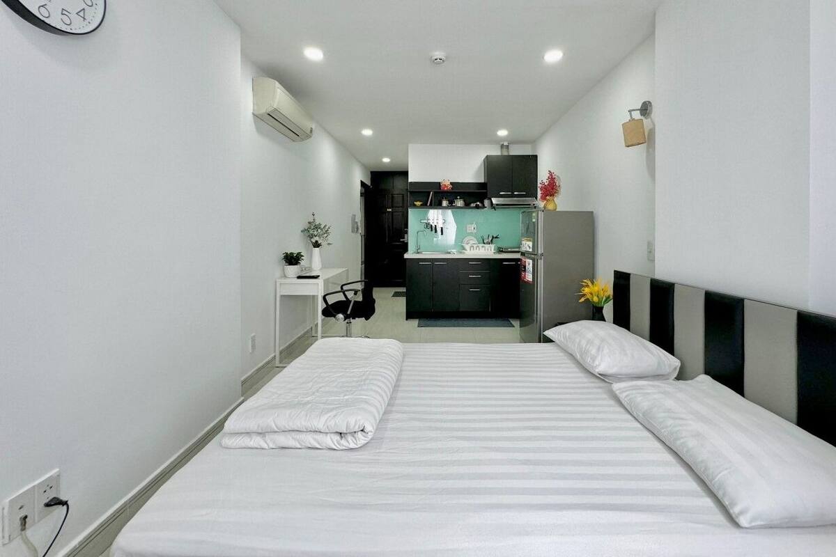 Une chambre d’hôtel avec un lit, un bureau et une kitchenette.