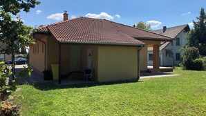 Eenlaags huis met pannendak en een klein portaaltje.