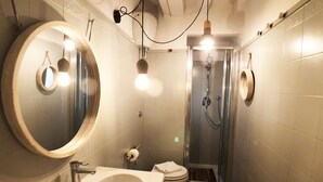 Ein kleines Badezimmer mit Waschbecken, Spiegel, Toilette und Dusche.