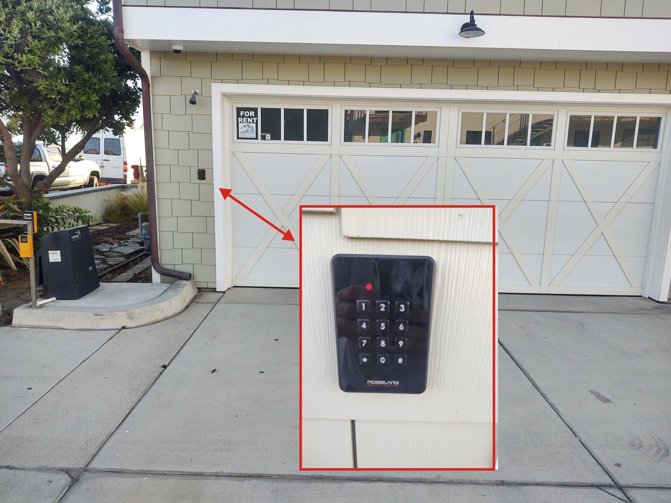 Una cerradura electrónica en la puerta de un garaje con un cartel que dice 'For Rent' encima.