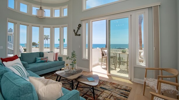 Un salon spacieux doté d’une grande fenêtre donnant sur l’océan, d’un coin salon confortable et d’un balcon avec vue.