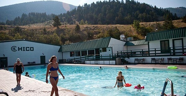 Une zone avec piscine, avec un bâtiment portant l’inscription « HICO » en arrière-plan, le tout entouré de collines.
