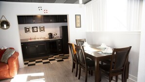 A modern kitchen with dark cabinets, a dining area with a wooden table and chairs, and a checkered floor. - Ft Walton cozy condo w/ on-site pool. Near beaches (Fort Walton Beach)