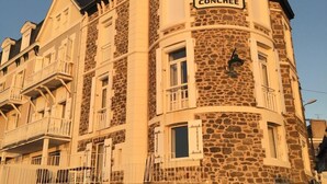 Ein Steinhaus mit einem Schild mit der Aufschrift 'LA CONCHÉE' und einem Balkon.