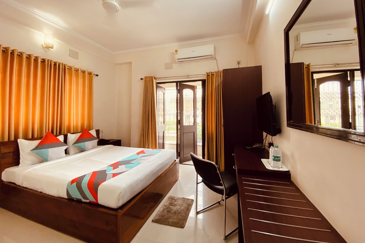 Une chambre d’hôtel équipée d’un lit, d’un bureau, d’une chaise, d’une télévision et d’un appareil de climatisation.