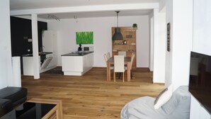 A modern apartment with a kitchen, dining area, and living room.