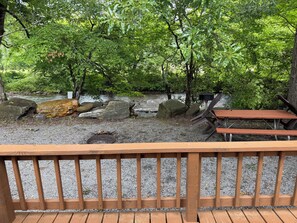 A wooden deck with a view of a river and surrounding trees. - Creekside Cabins - Mountain Laurel (Bryson City)