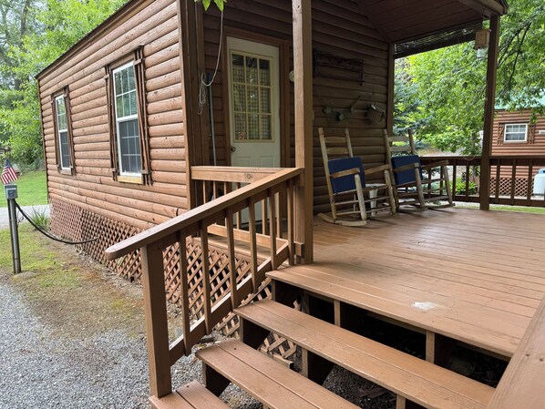 A wooden cabin with a porch, a bench, and a rocking chair. - Creekside Cabins - Mountain Laurel (Bryson City)