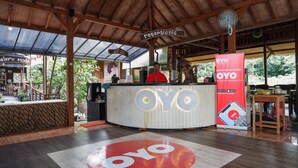 Un espace d’accueil doté d’un plafond en bois, d’un comptoir de réception et d’une enseigne indiquant « réception ».