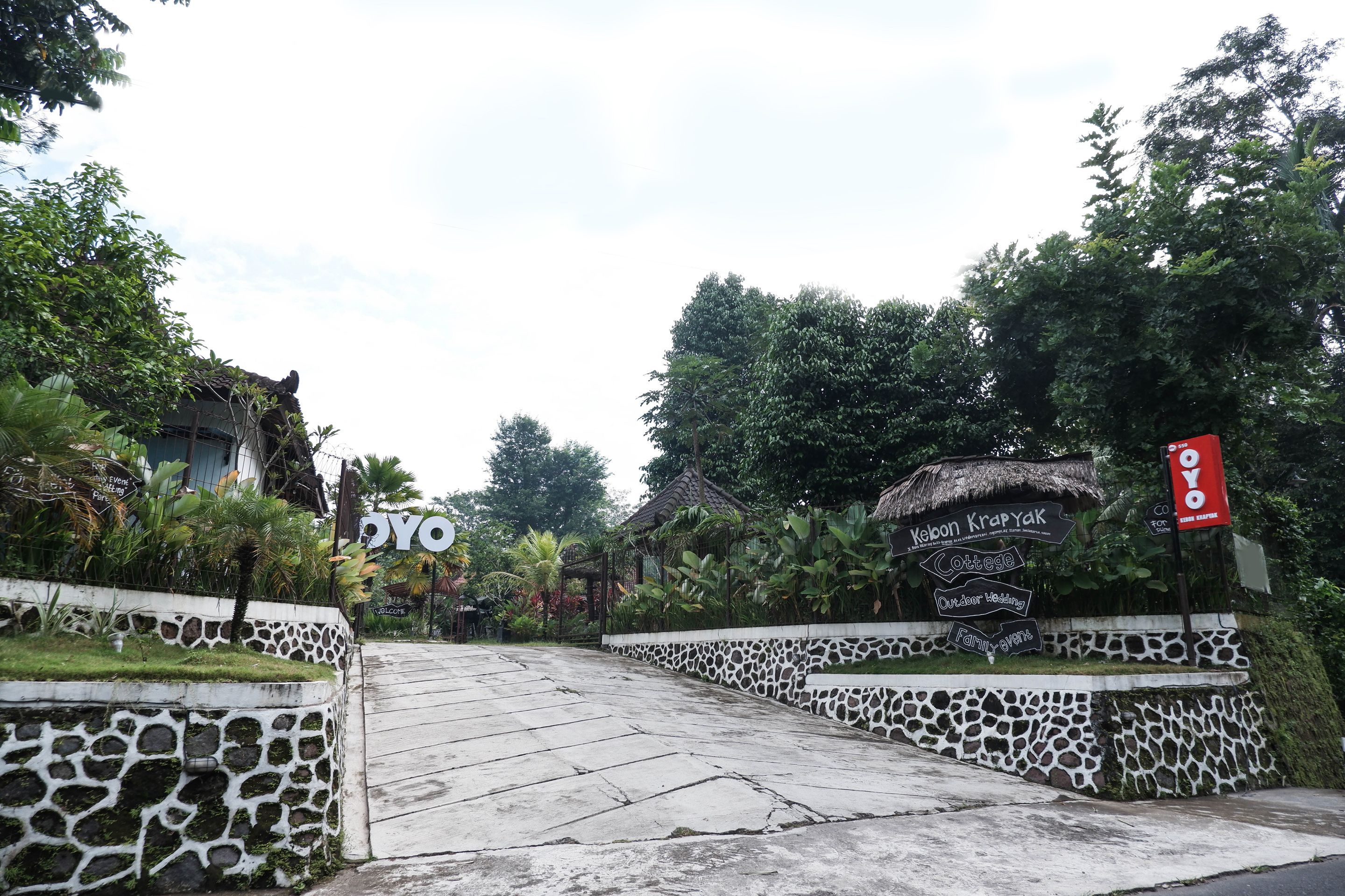 A pathway leading to a building with a sign reading "Kelon KrpyaK" and "Cottage Outdoor Wedding."