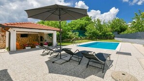 A backyard with a swimming pool, lounge chairs, and a covered patio area. - Villa Tea in Imotski, private pool (Zmijavci)