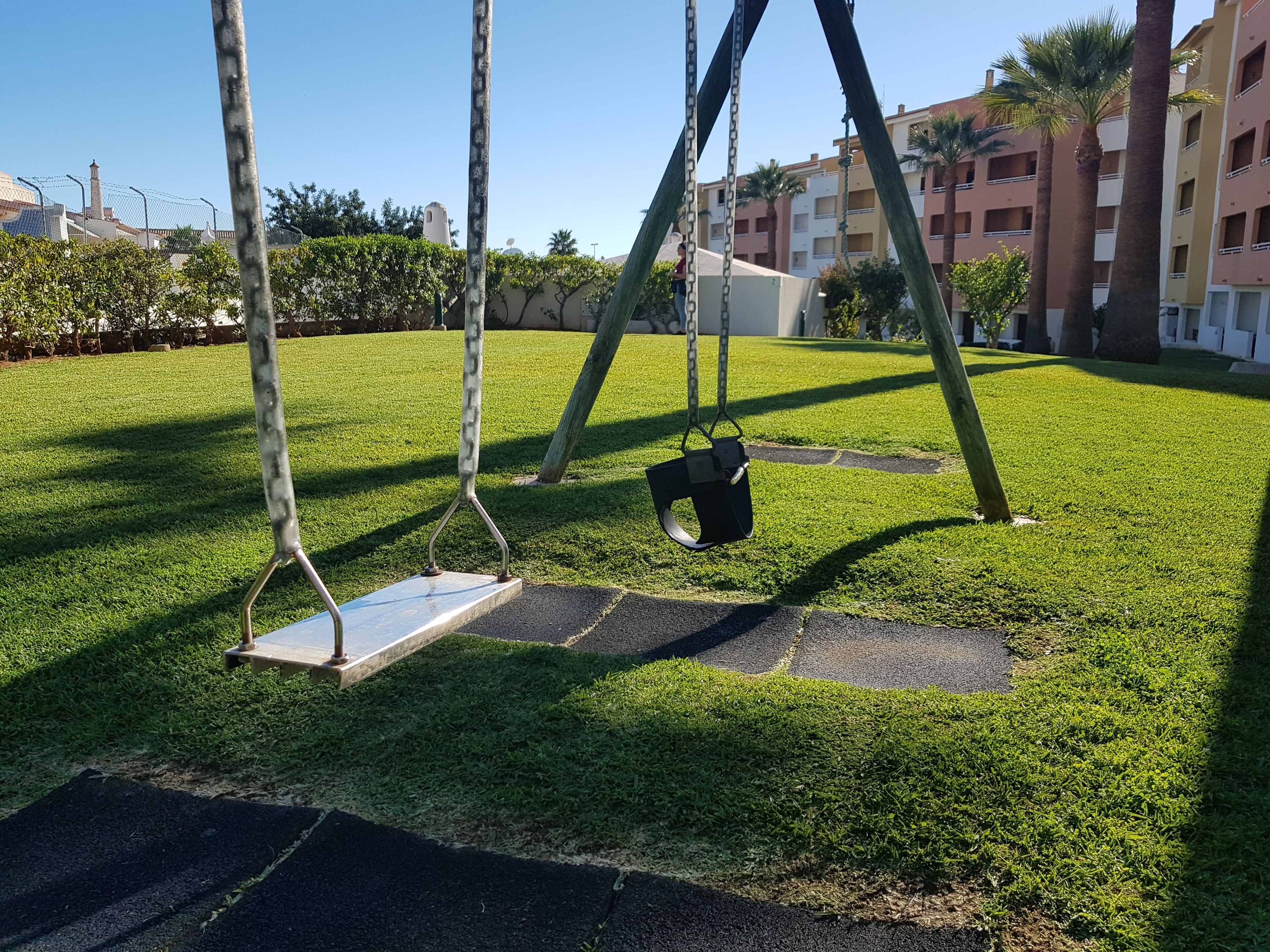 A playground with swings and a sandbox.