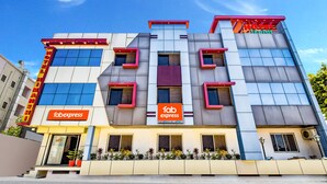 Un hotel moderno con un letrero de 'Fab Express', múltiples ventanas y una fachada plana.