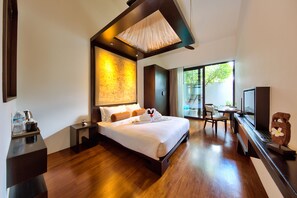 A modern hotel room with a large bed, a desk with a laptop, a television, and a view of the outdoors.