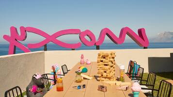 A wooden table with various items including a stack of wooden blocks, a pineapple, a pink flamingo, and a pink ice cream cone.
