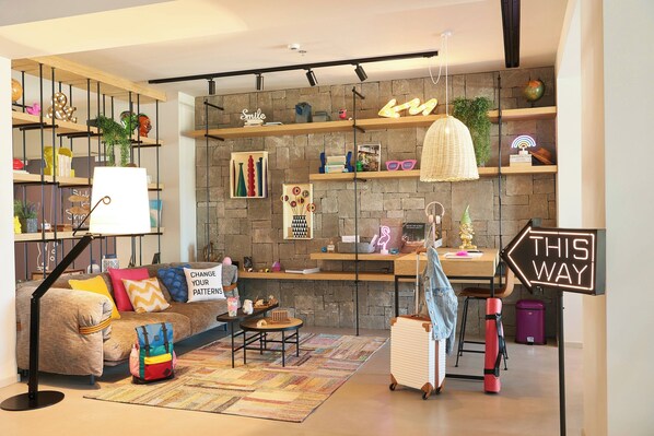 A modern living room with a sofa, coffee table, and shelves with decorative items.