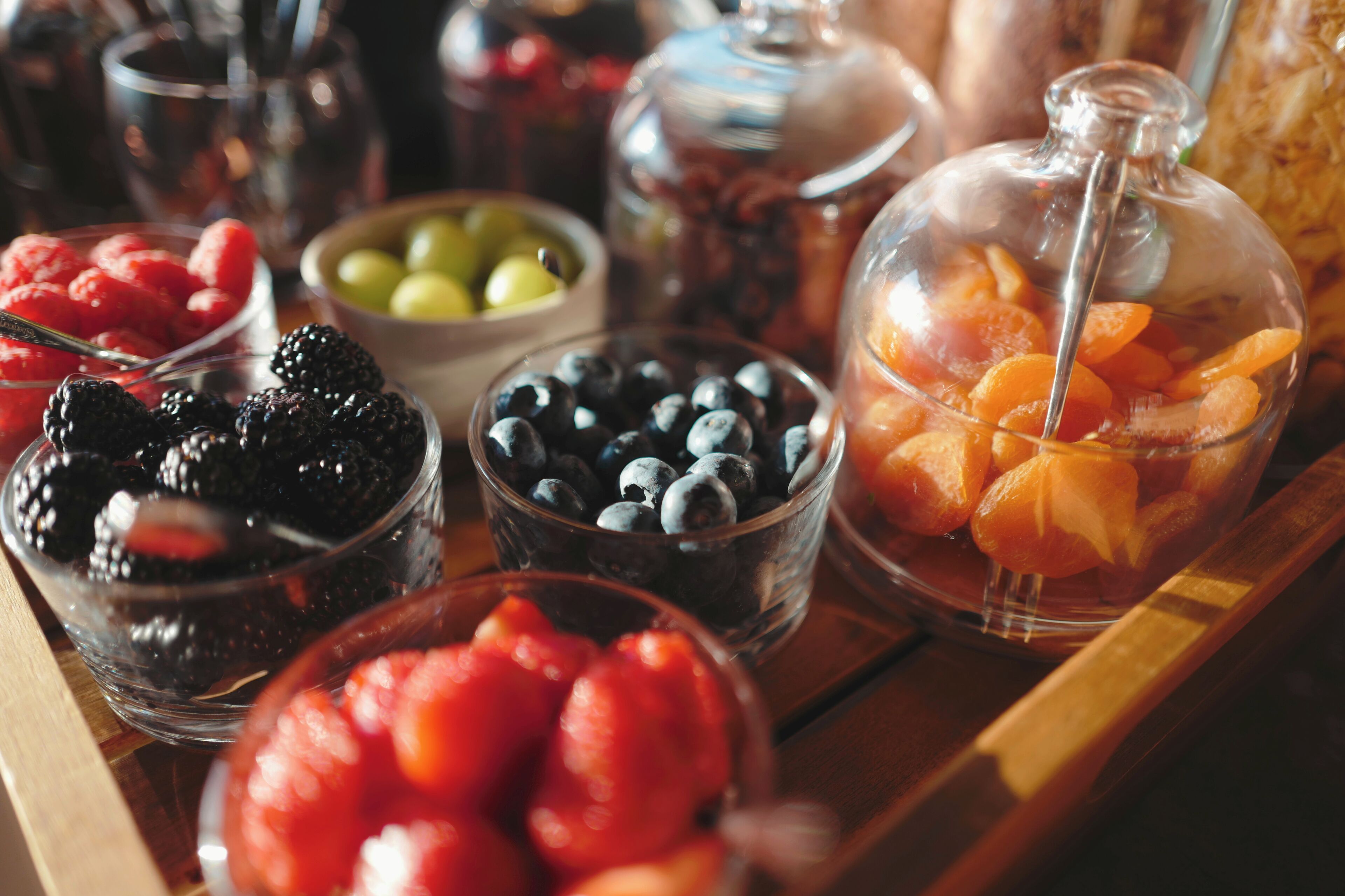 A variety of fruits and beverages on a wooden table.