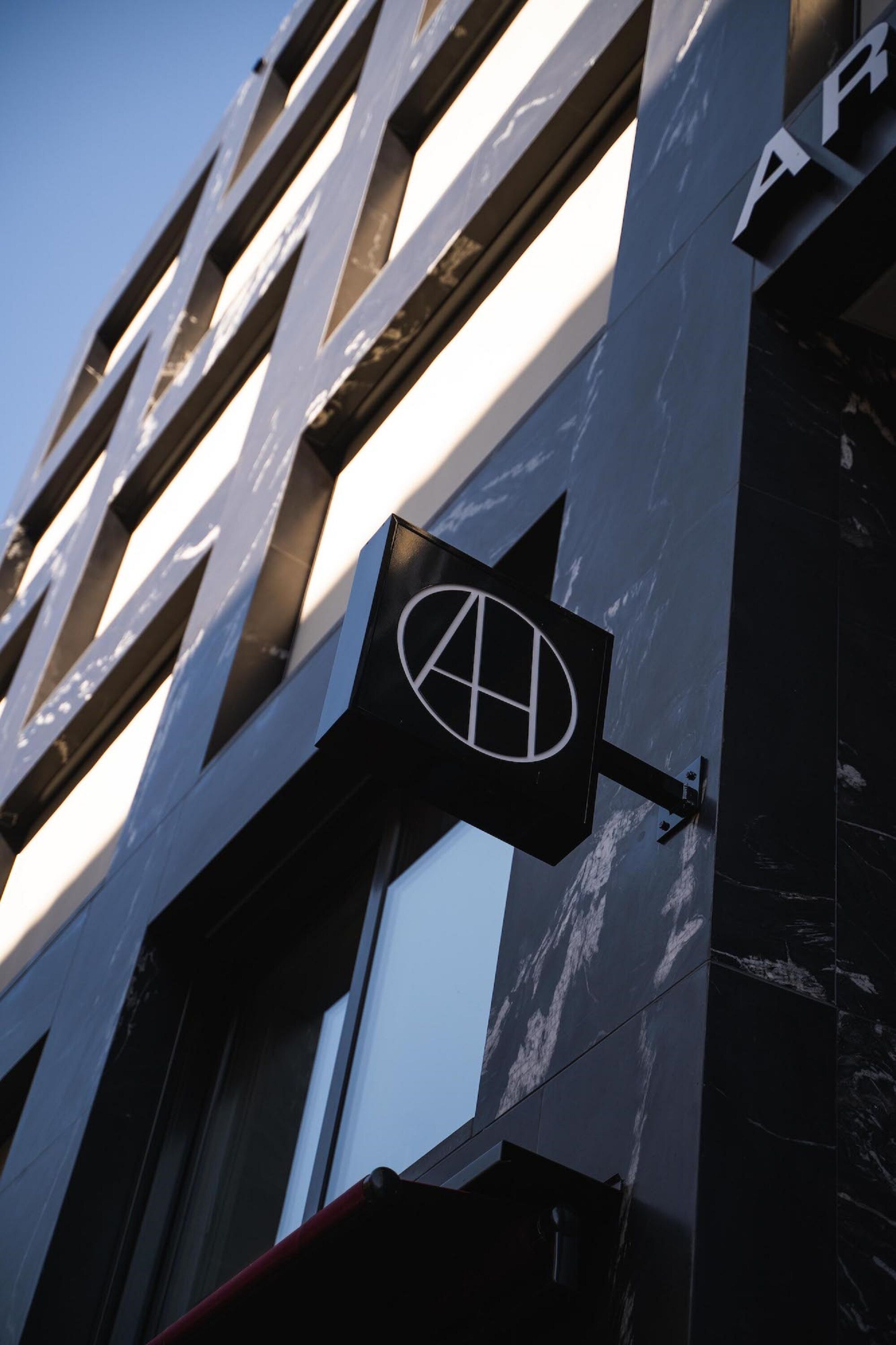 Fachada de edifício com um logotipo em destaque e as letras 