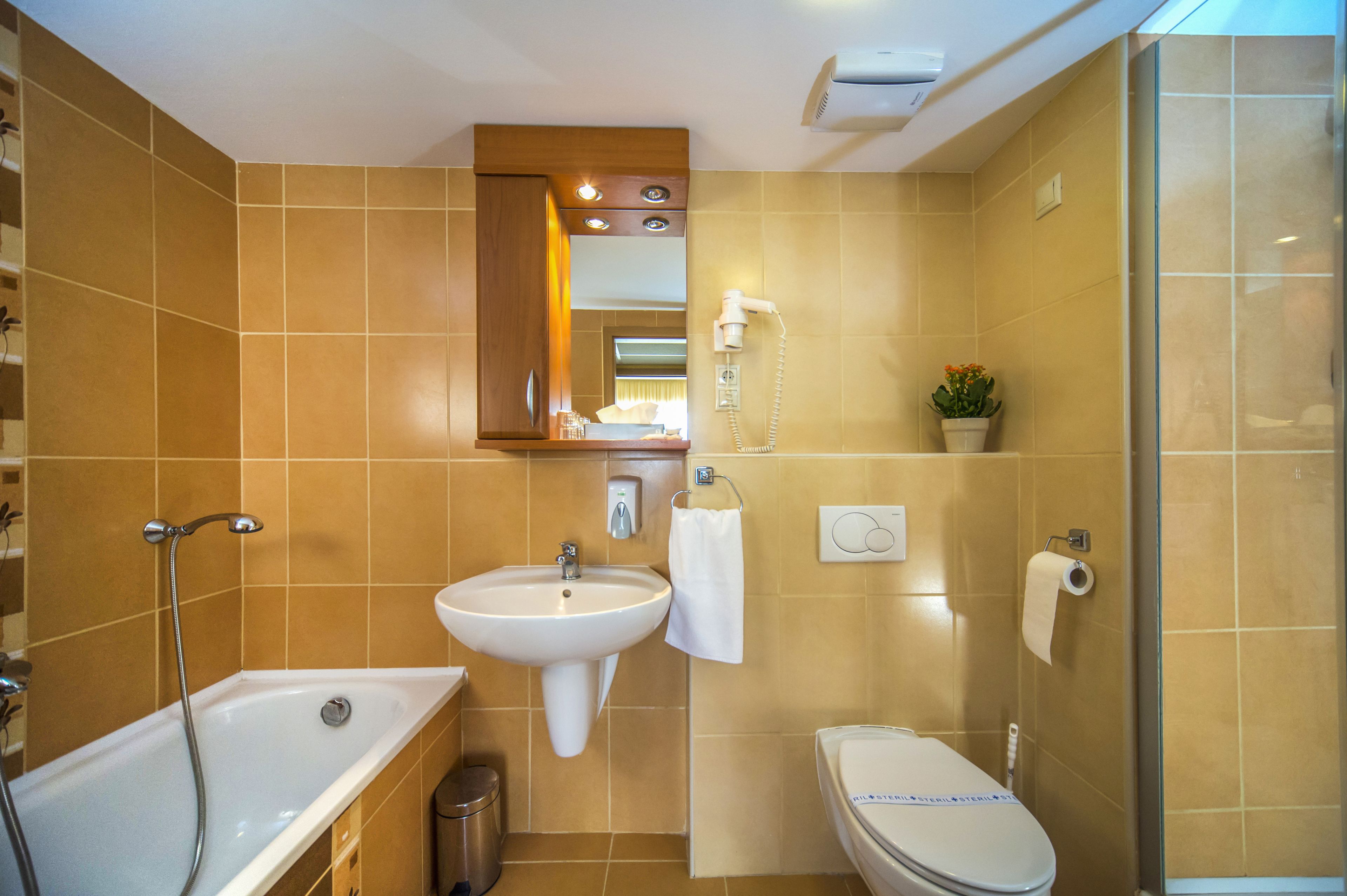 A bathroom with a bathtub, sink, toilet, and a glass shower enclosure.