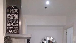 A kitchen with a stainless steel kettle, a wall clock, and a water dispenser.